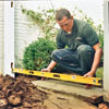 man with measurement tool near ground
