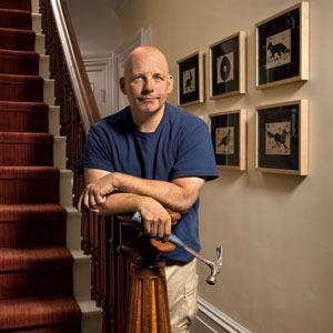 Scott Omelianuk leans on a baluster with framed artwork behind him, a new acquisition is inset at bottom right