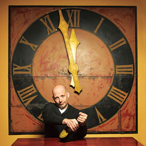 TOH Editor Scott Omelianuk sitting with a bottle champagne below a clock about to strike midnight
