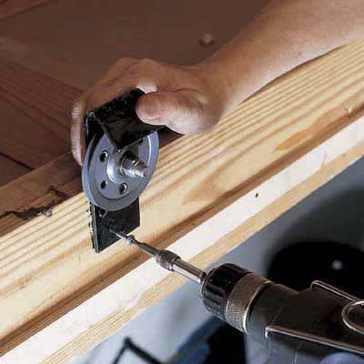 Install cable pulleys to enable pulley system to slide stairs down when attic door is opened