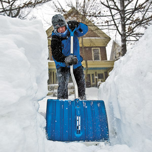 man digging out his car from snow