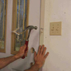 Temporarily secure the door by nailing through the predrilled holes in the steel frame and into the wall framing