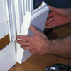 Apply adhesive to the back of the plinth blocks and nail one to the bottom of each column