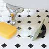 Swiping grout into the joints with a rubber grout float