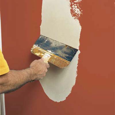 applying a final coat of joint compound to cover drywall patch seams