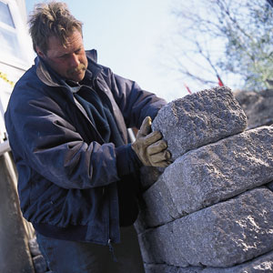 Roger Cook inspects a cobblestone retaining wall