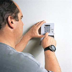 Richard Trethewey adjusts a programmable thermostat