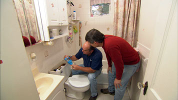 two people installing a new dual flush feature to a toilet bowl