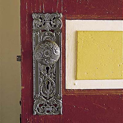 century-old brass doorknob and red, yellow, and cream paint on Queen Anne door