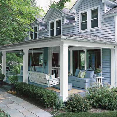 outdoor room with plush, comfortable furniture, white porch swing, and end table with potted plant