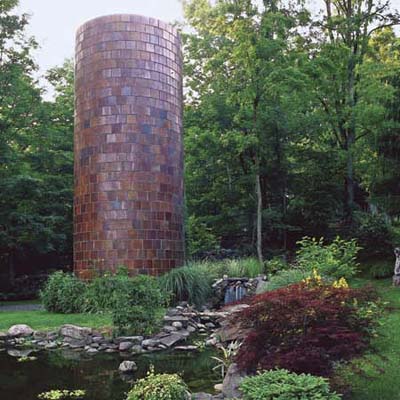 yard with pond, shrubbery and large brick column