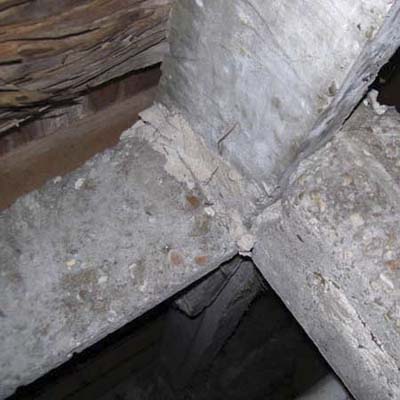 old newspapers sticking out from between concrete posts from when the posts were first poured