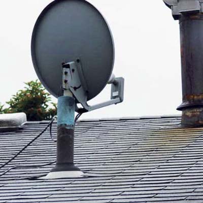 satellite dish mounted inside a plumbing vent pipe on the roof of a house