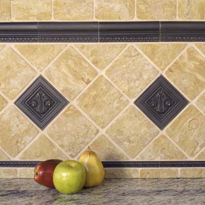 bronze tiles made by Saint-Gaudens used in a backsplash with fruit in the foreground eco friendly