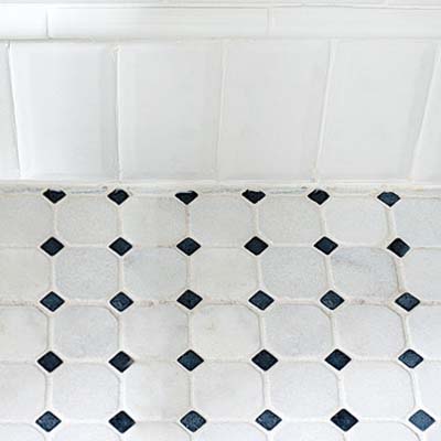 creative use of subway tile makes a baseboard for this classic twenties style remodeled bath