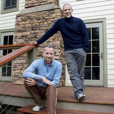 homeowners on the side stairs of their newly remodeled farmhouse