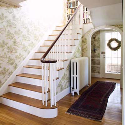existing stairwell before remodel with glimpse of landing bookshelves that will be expanded to a full library