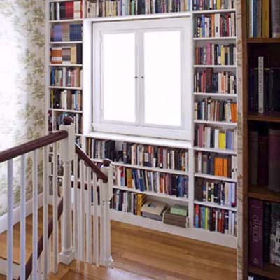 current landing before remodel with bookshelves framing the second-floor landing window