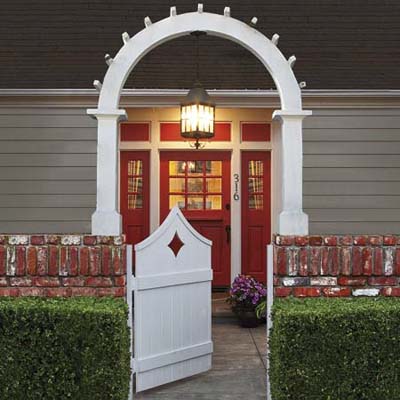 entryway with red-painted door and white archway