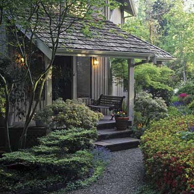 entryway with shrub-lined winding curve leading to front entry