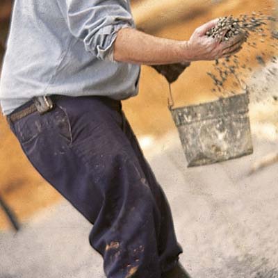man scattering the mud mix 