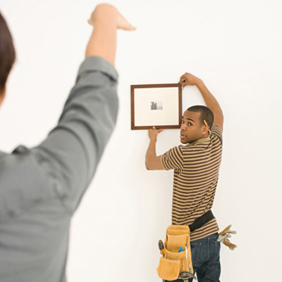 woman telling contractor where to hang frame
