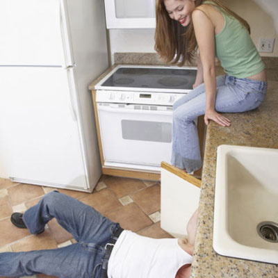 woman watching contractor working under sink