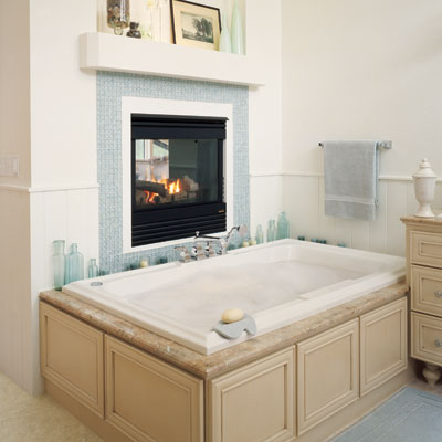 a gas fireplace over a large bathtub