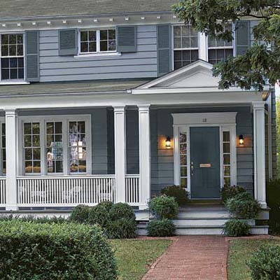 a closeup of a house with a porch addition and new front door and repainted siding