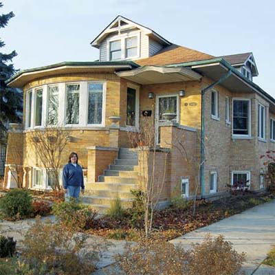 woman standing in front of her brick craftsman home in this chicago illinois best old house neighborhood