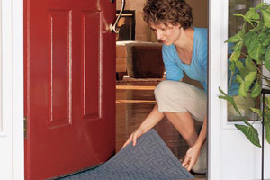 woman placing doormat on entryway floor