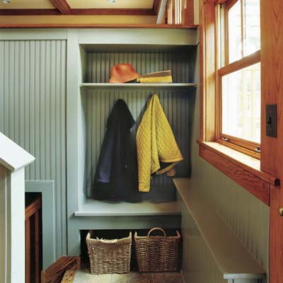 stair landing mudroom with coat hooks and storage baskets