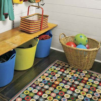 bench seating with rubber bins and wood floor protected with patterned rug 