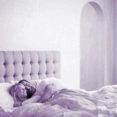 man and woman cuddling in bed