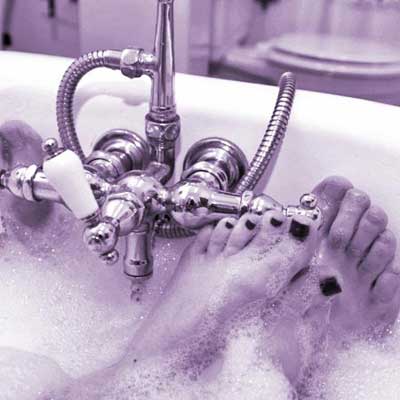 man and woman's feet in bathtub