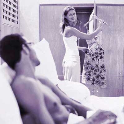 woman showing man dress in front of closet