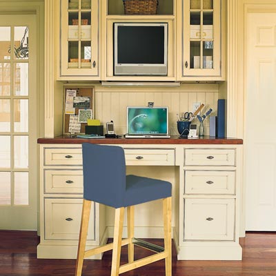 home office built into kitchen with computer and counter stool