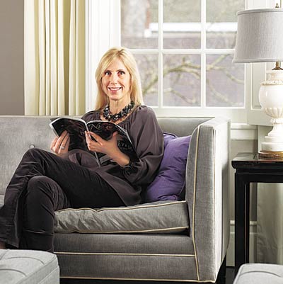 interior designer stephanie king sitting on tailored sofa in gray toned living room