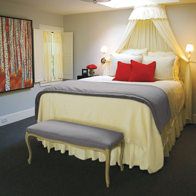 feminine bedroom in neutral tones with red accents