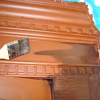 paintbrush creating faux wood stain on office cabinets