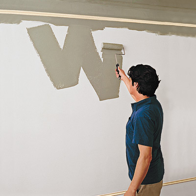 photo of man painting wall with roller