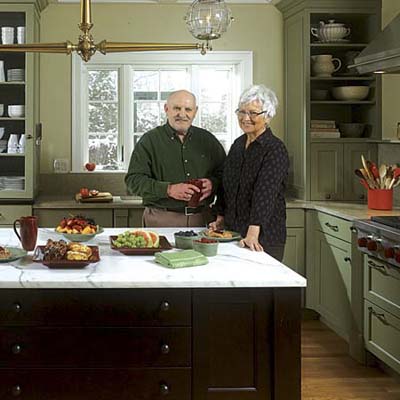 couple stands behind the island in their newly redesigned Georgian kitchen