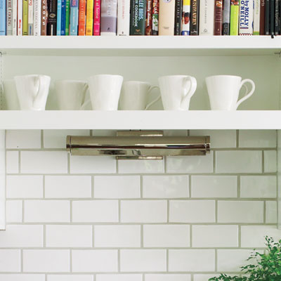 white airy kitchen with subway tile backsplash and chrome library light
