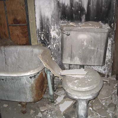 Bathroom before remodel with filthy tub and toilet