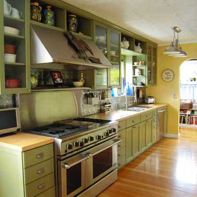 updated kitchen with green cabinets and stainless steel stove