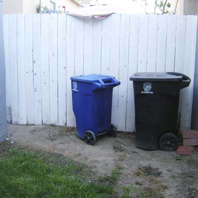 backyard fence with trash cans