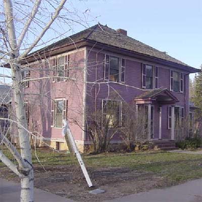 purple house with bare front lawn