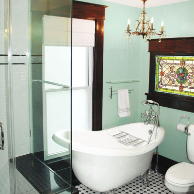 updated bathroom with stained glass window, chandelier and claw foot tub