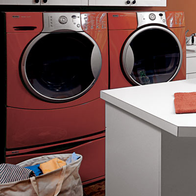 matching orange walls and washer dryer in family room laundry room
