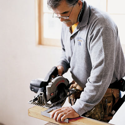 man using speed square to guide circular saw